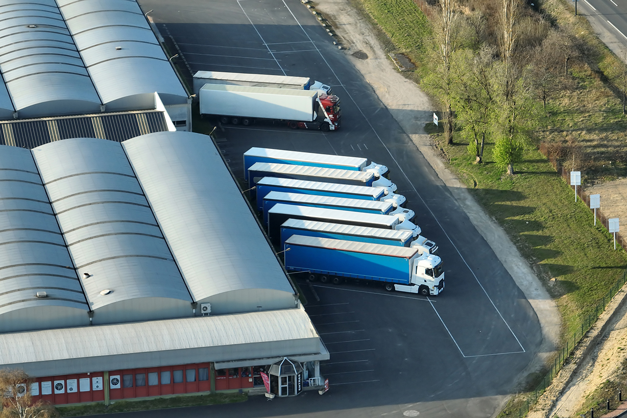 Aerial view of goods warehouses and logistics center in industrial city zone from above.
