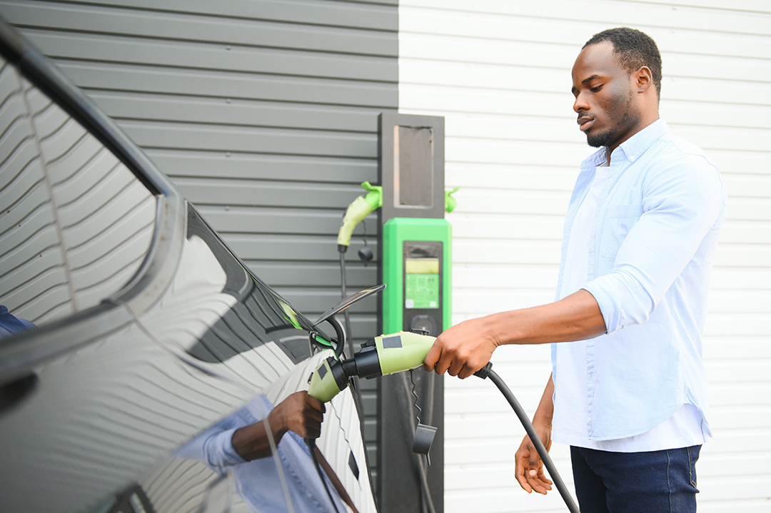 African American man charging his electric car