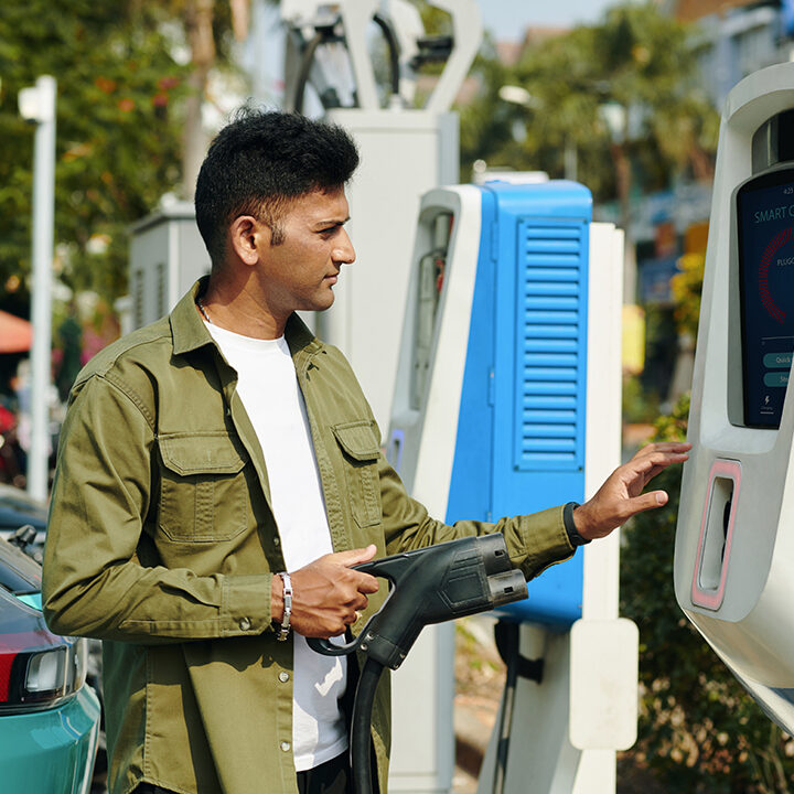 Ev owner entering information on screen of public charging station